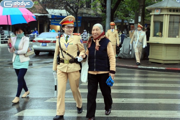 Nữ chiến sĩ cảnh sát giao thông ngoài việc phân làn còn giúp người già sang đường ở ngã tư